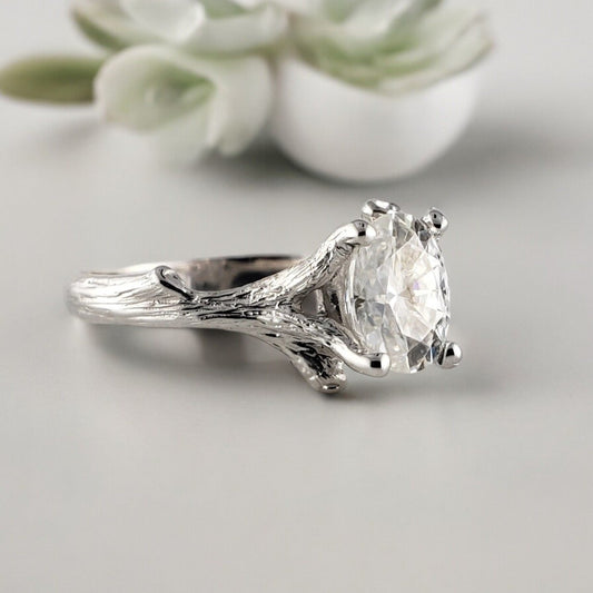 White gold twig engagement ring with an oval brilliant-cut gemstone held by branch-style prongs